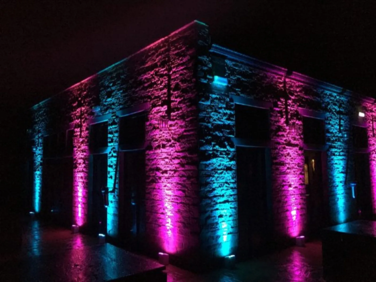 Blue and pink uplighters along a venue wall