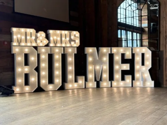 White MR & MRS BULMER light up letters at a wedding